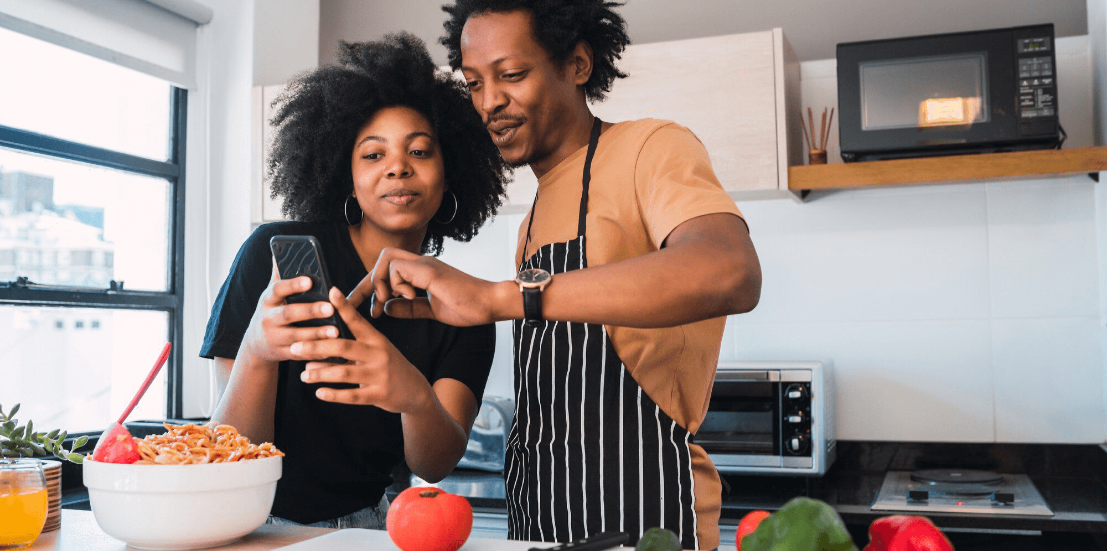 A couple in their kitchen placing a Giddgo order on a phone